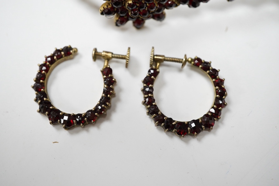 Three items of gilt white metal and garnet paste cluster set jewellery, comprising a bracelet, bangle and pair of Czechoslovakian earrings. Condition - fair